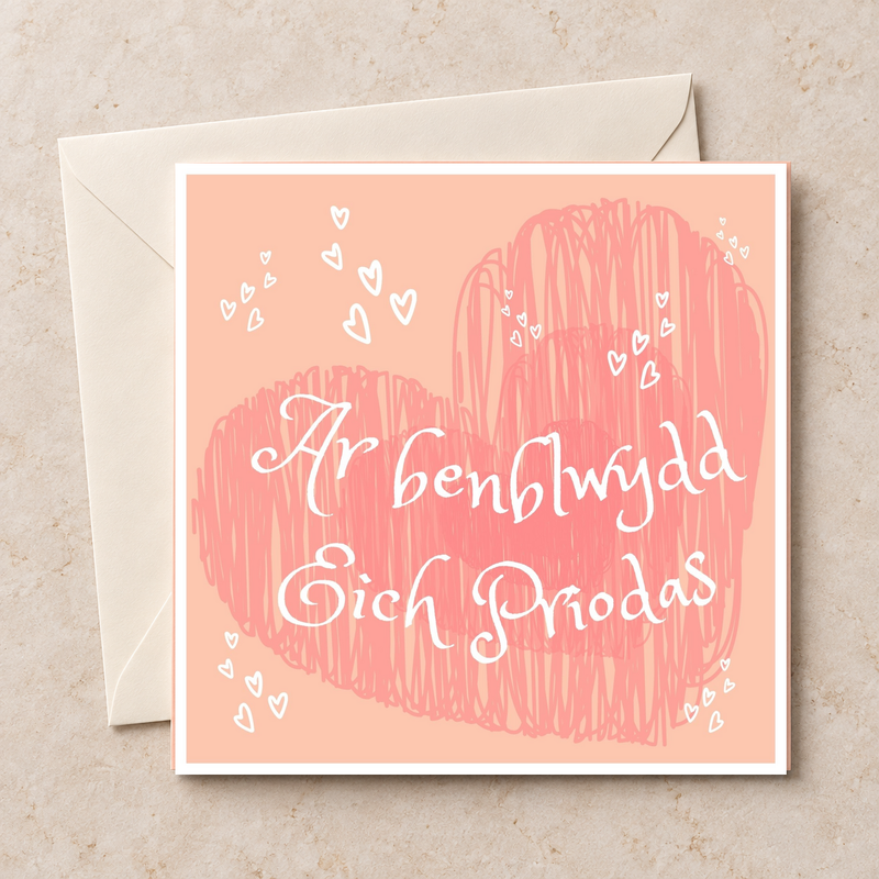 Cerdyn Ar Benblwydd Eich Priodas gyda chalonnau pinc, yn wastad gydag amlen ifori / Welsh anniversary card shown flat with an ivory envelope.