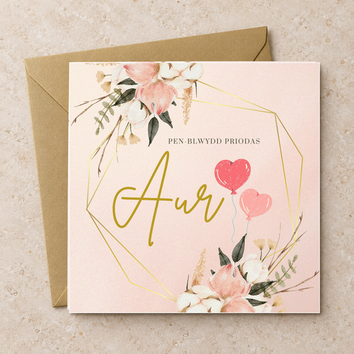 Cerdyn Pen-blwydd Priodas Aur gyda blodau pinc a manylion aur, yn wastad gydag amlen aur / Welsh golden anniversary card shown flat with a gold envelope.